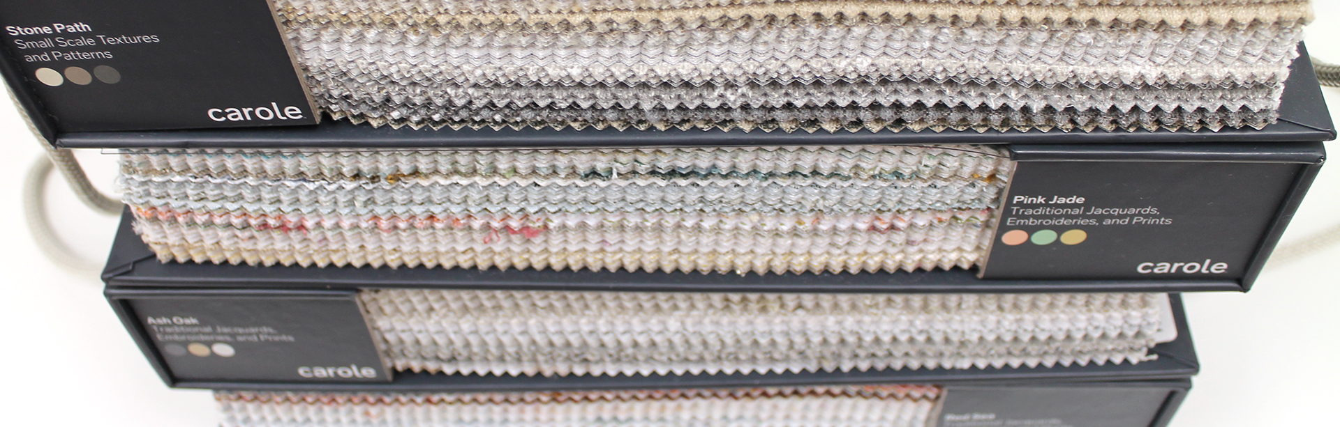 site-homepage-banner-3 Looking down the side of a stack of fabric sample books from the Carole Fabrics Spring 2021 Collection.