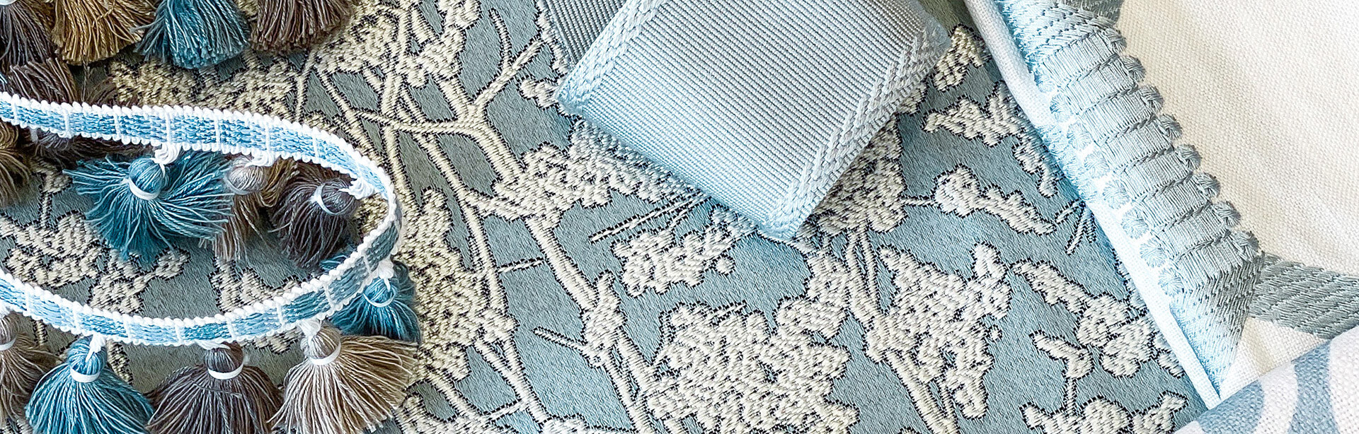 Designs-That-Inspire-Banner-042121cmp An airy assortment of fabrics and trimmings in light blues and whites with accents of brown.