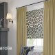 Animal print flat roman shades complemented by golden pleated draperies.
