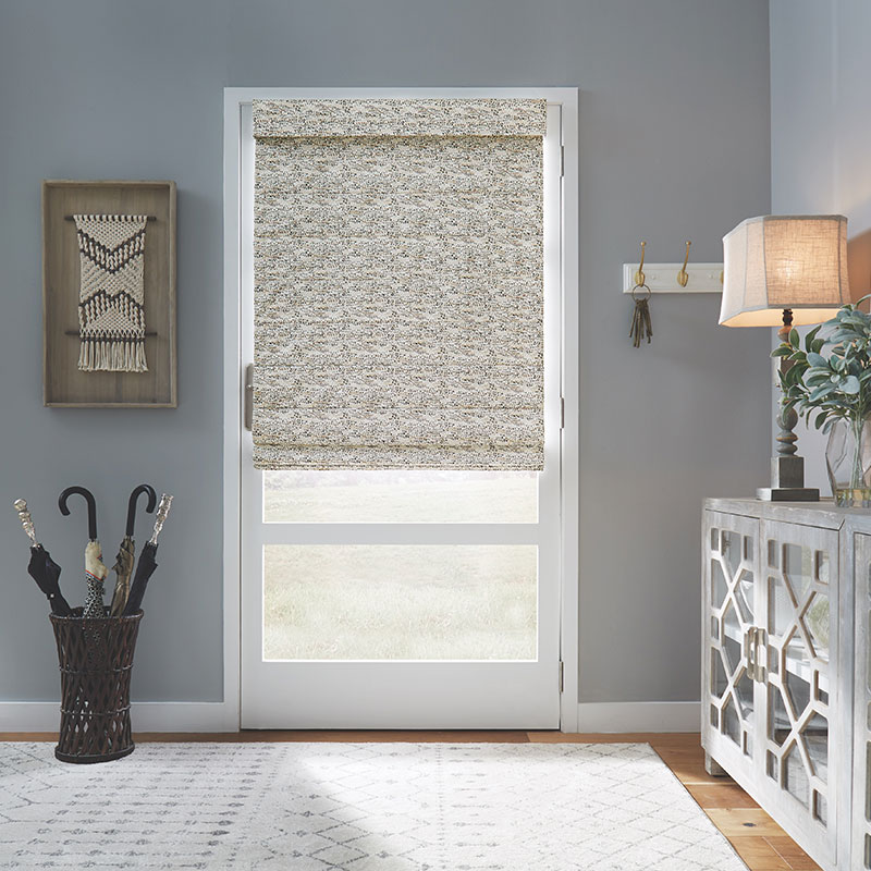 A top-down, bottom-up shade in a small scale neutral pattern on a glass door.