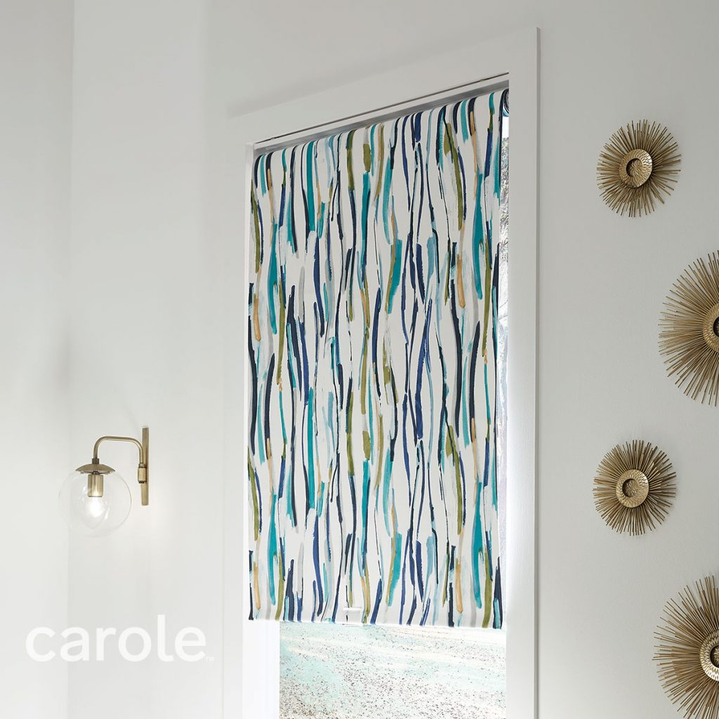 Angled view of a Reverse Roll Inside Mount Decorative Fabric Roller Shade with an abstract print in a white room.