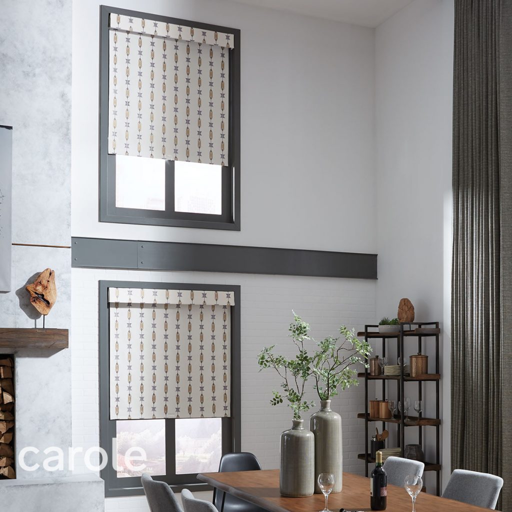 A dining room in earth tones featuring two windows with Standard Roll Inside Mount Decorative Fabric Roller Shades and Attached Valances.