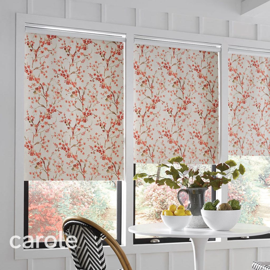 A white dining room featuring three windows with Standard Roll Inside Mount Decorative Fabric Roller Shades in a red and white floral pattern.