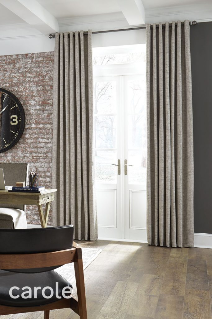 Grommet Heading Drapery in beige over white French doors in an office with a rustic brick wall.