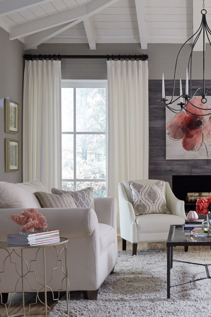 White Inverted Pleat Drapery in a soft neutral living room with dark pink accents.