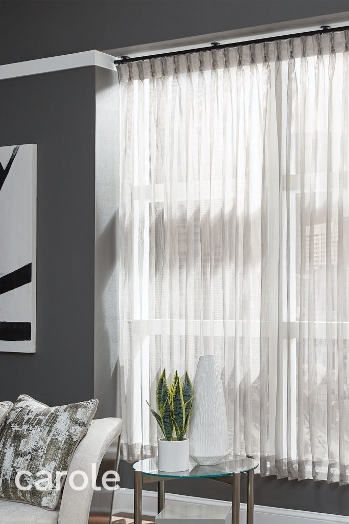 Sheer gray Monarch Pleat Drapery in a dark grey living room with white accents.