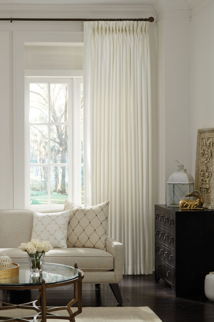 Ivory Three Finger Pinch Pleat Drapery in a warm neutral living room.