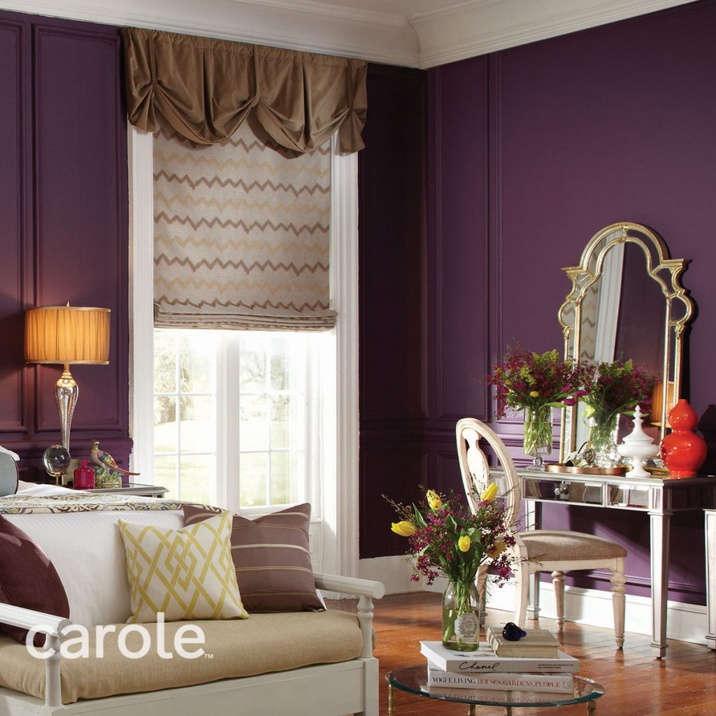 Gold Danby Rod Mounted Valance top treatment over a zig-zag patterned Flat Roman Shade in an opulent purple room.