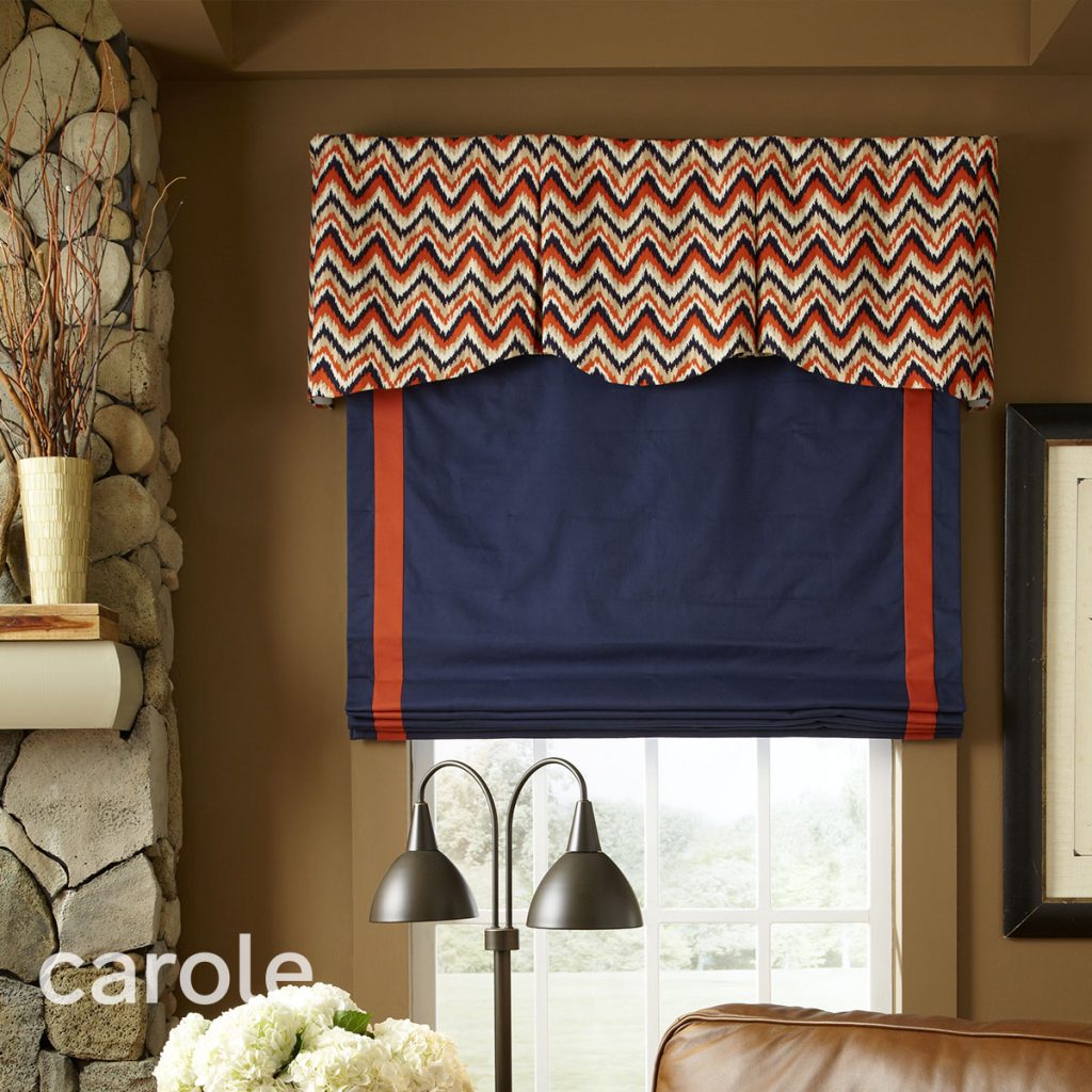 Lifton Rod Mounted Valance top treatment with a bold zig-zag pattern over a red Flat Roman Shade with red trim in a casual room.