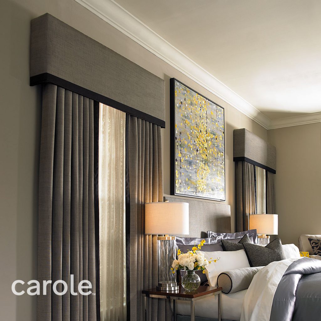 Statler Cornice top treatment in beige with black trim over Draperies in beige with black trim and ivory sheers in a dark neutral bedroom.