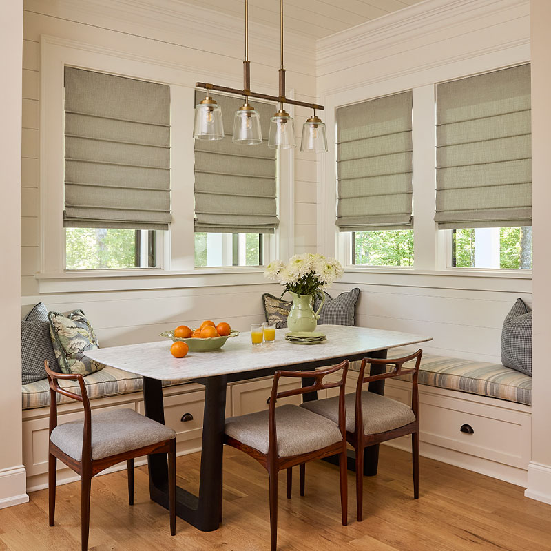 A kitchen dining nook with custom Front Fold Roman Shades on found windows.