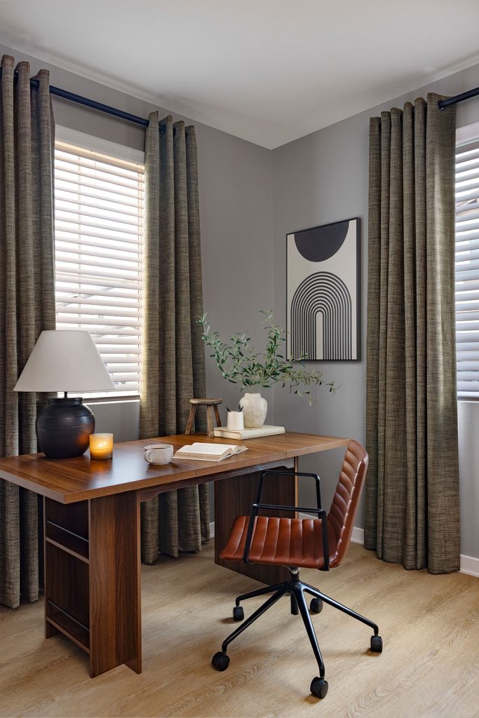 A cozy home office with medium grey walls and windows featuring Grommet Heading EZ Panels.