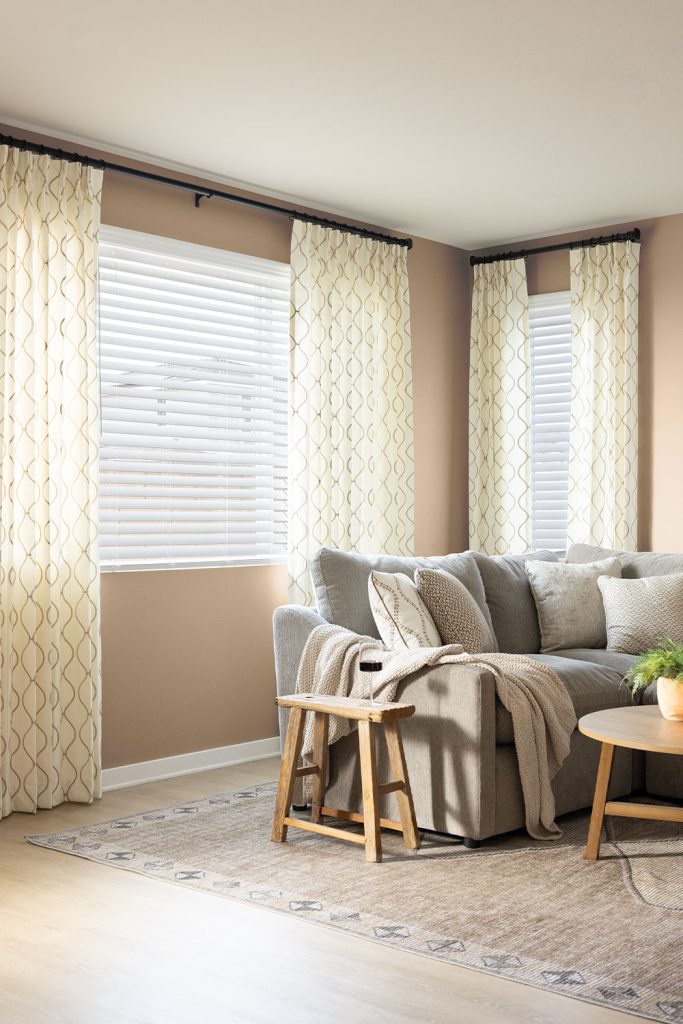 A neutral great room with different sized windows featuring Two Finger Pinch Pleat EZ Panels