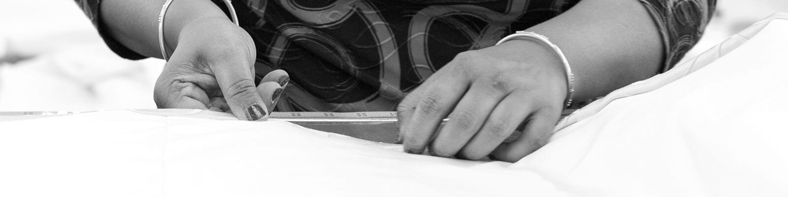 Close up of a woman's hands measuring fabric.